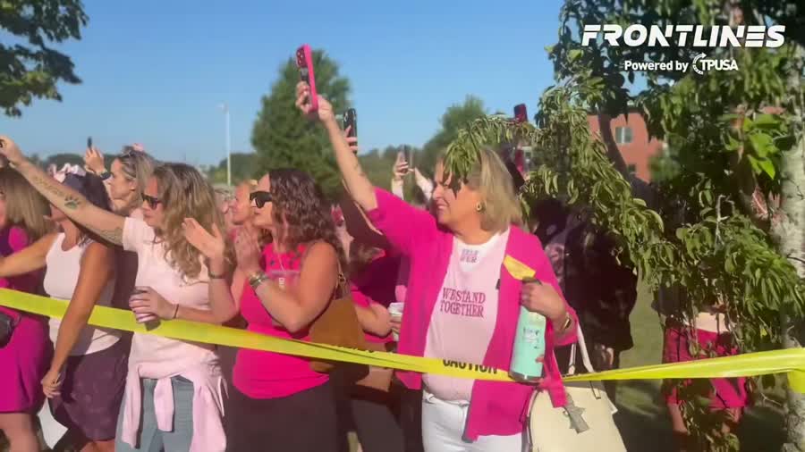 Multidão vestida de rosa em apoio a Lindsay Clancy, com camisetas 'We Stand Together'