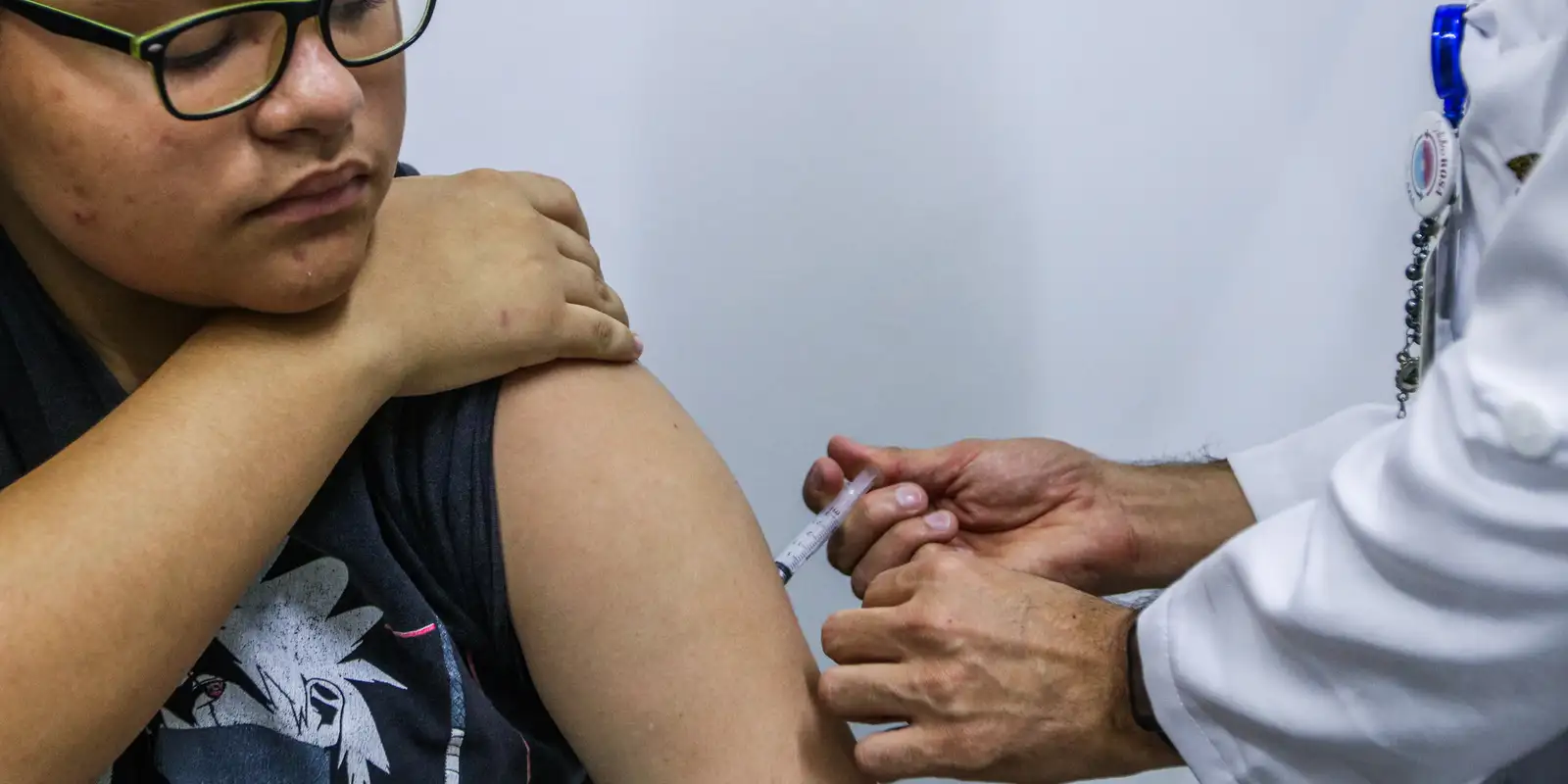 Adolescente recebendo vacina contra a dengue