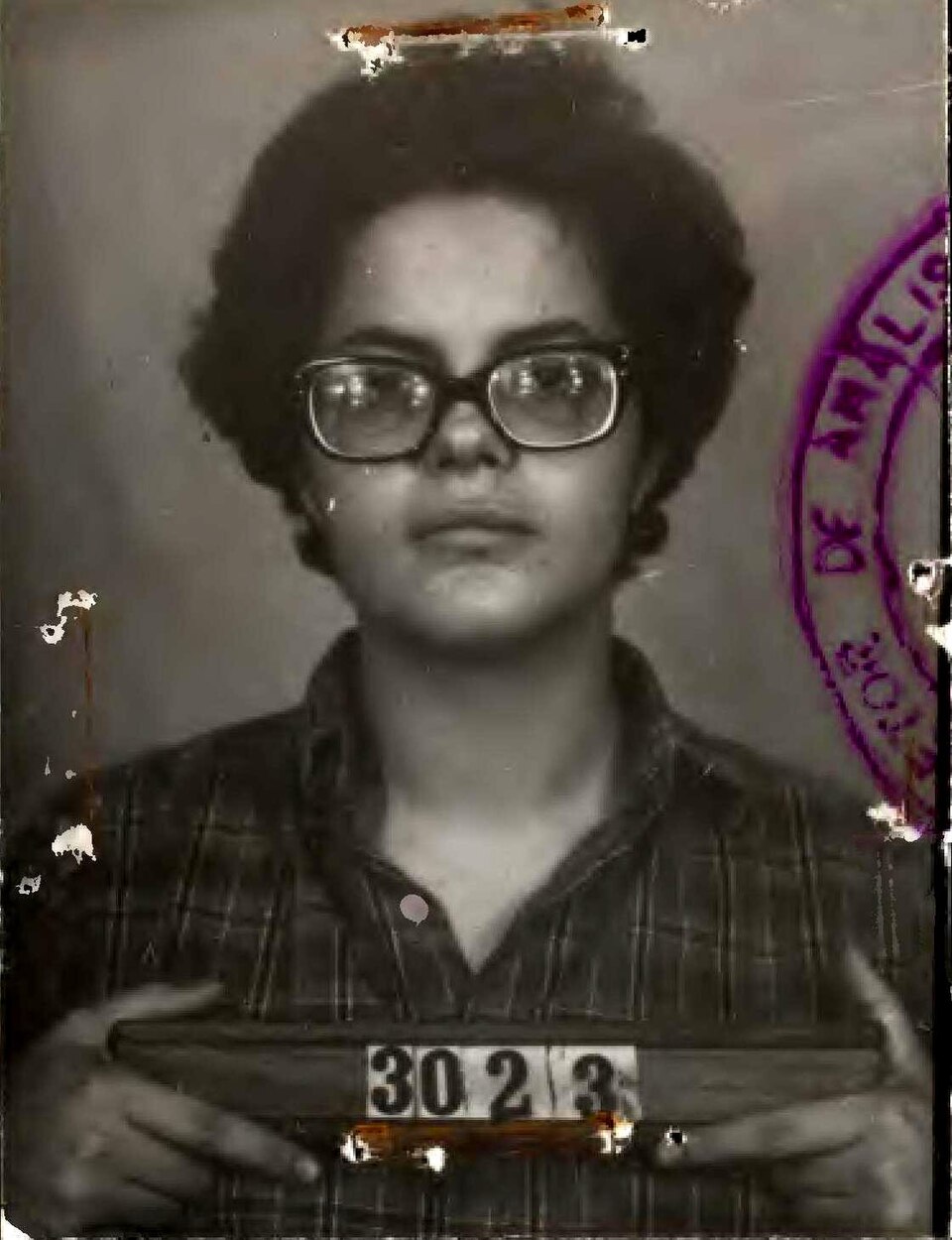 Ficha de identificação de Dilma Rousseff no DOPS, 1970, segurando a placa com o número 3023.