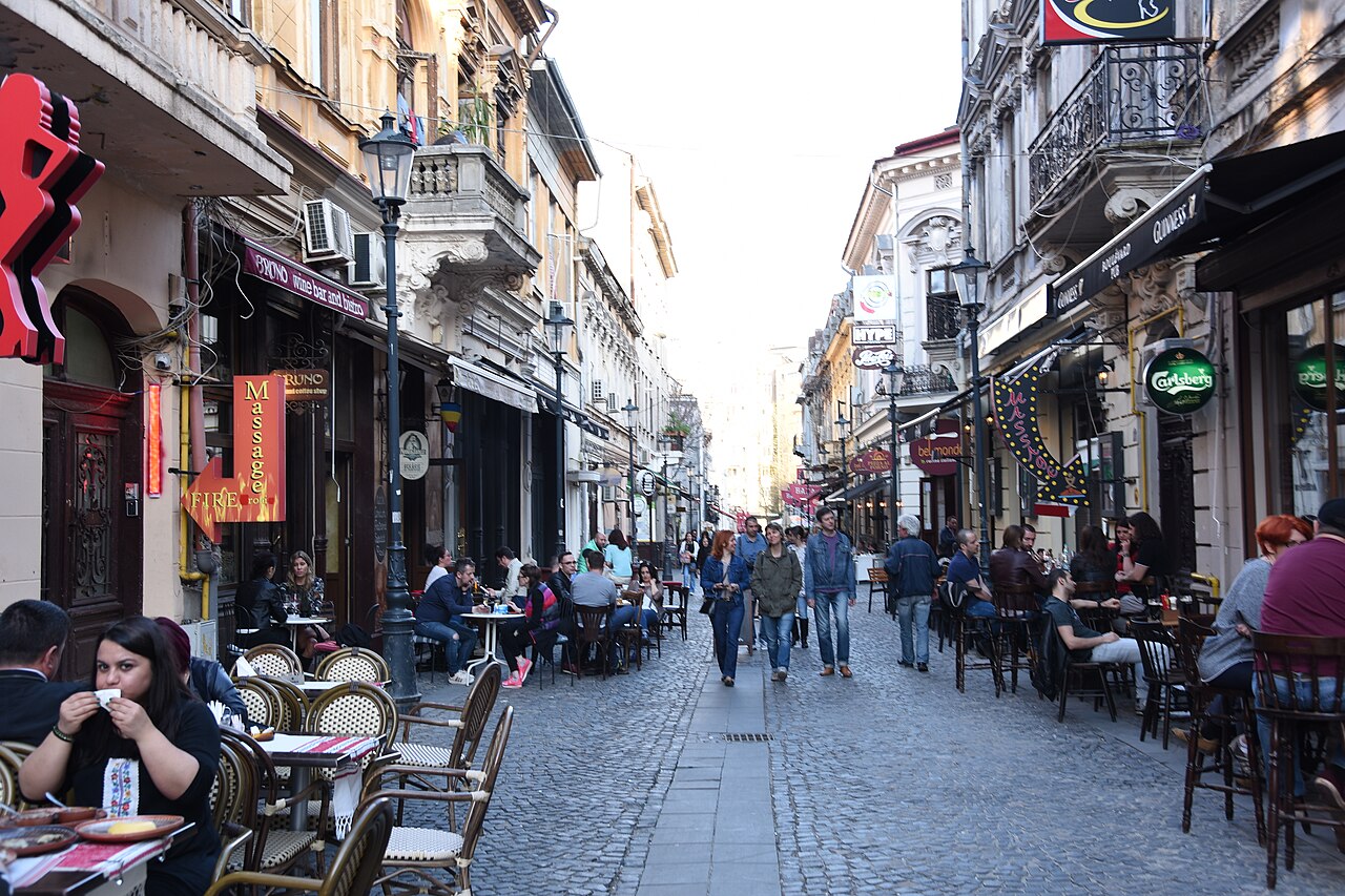 Rua do centro histórico de Bucareste, com comércio e restaurantes.